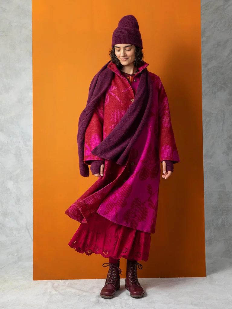 A woman wearing a hot pink wool coat from Gudrun Sjödén. 