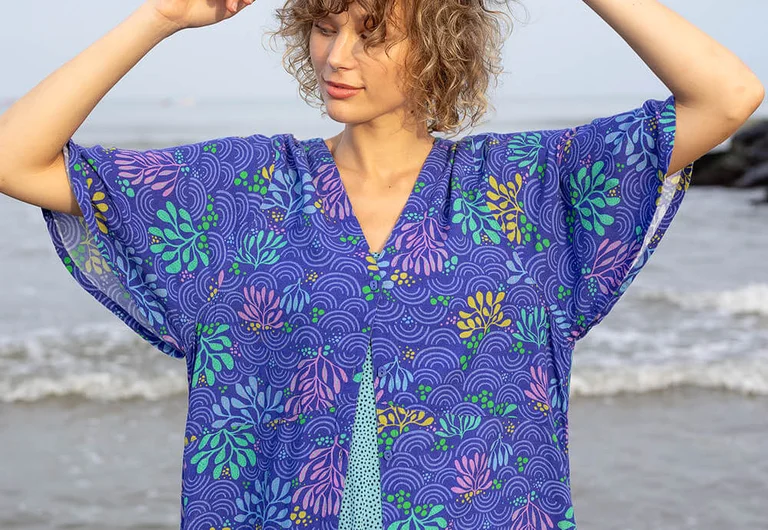 Een vrouw in een blauwe gedessineerde jurk van Gudrun Sjödén.