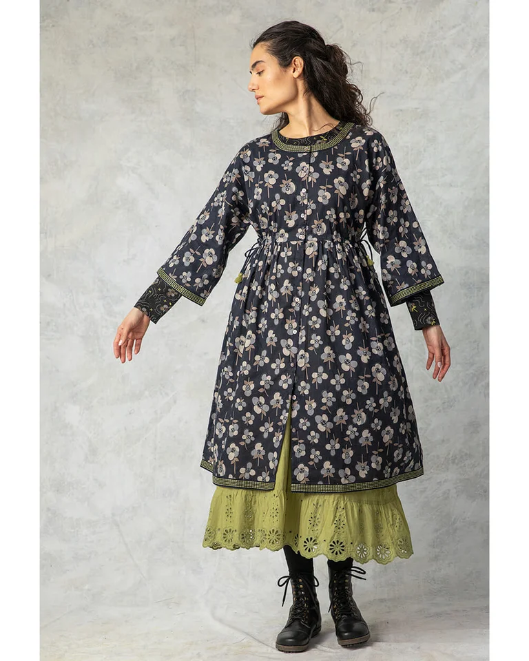 A woman wearing a black floral dress from Gudrun Sjödén.