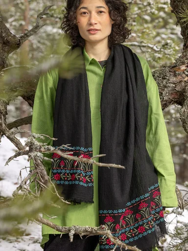 Eine Frau in einem schwarzen Schal von Gudrun Sjödén. 
