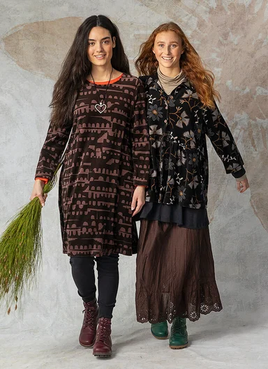 Two women wearing layers of dark clothes from Gudrun Sjödén.