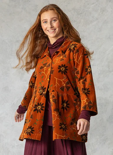 A woman wearing a patterned velour cardigan from Gudrun Sjödén.