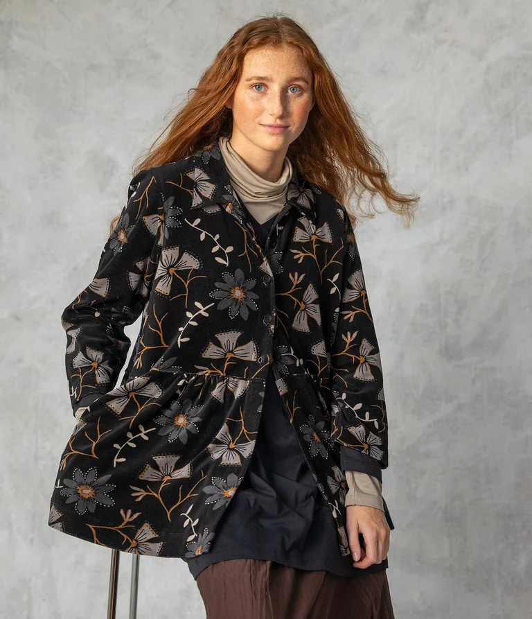 A woman wearing a velour cardigan from Gudrun Sjödén.