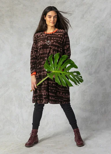 A woman wearing a patterned velour dress from Gudrun Sjödén.