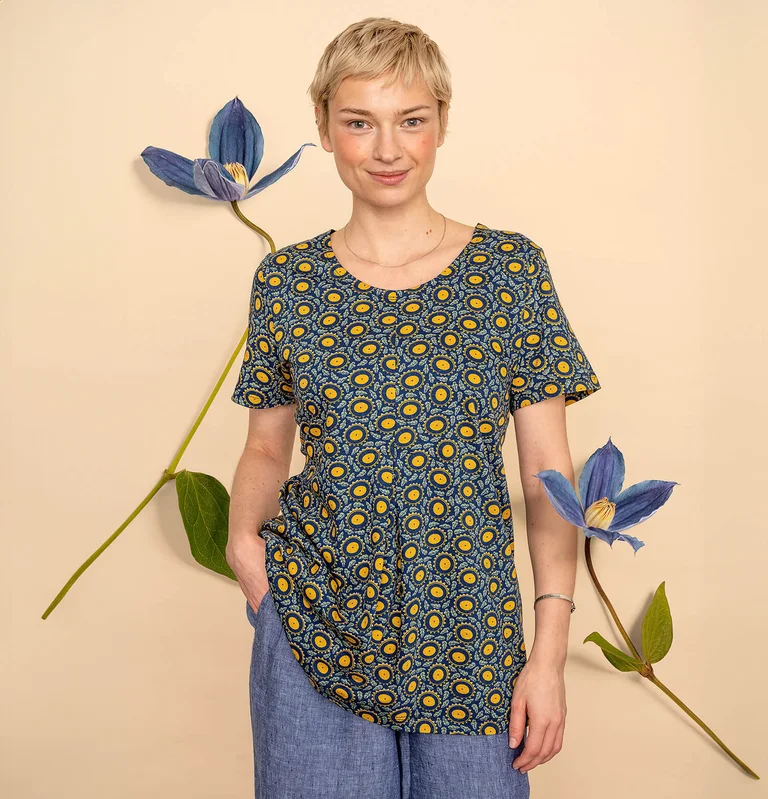 A woman wearing a top with a sunflower pattern from Gudrun Sjödén. 