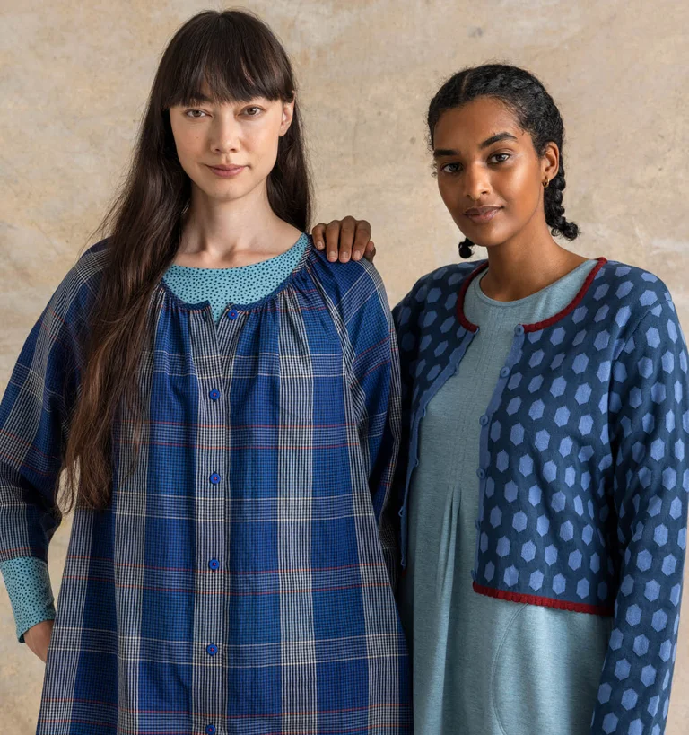 Two women standing together wearing layers of essential clothes in shades of blue from Gudrun Sjödén.