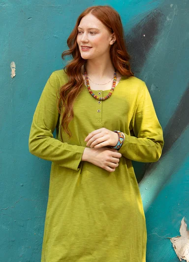 A woman wearing layers of clothes in shades of green from Gudrun Sjödén. 