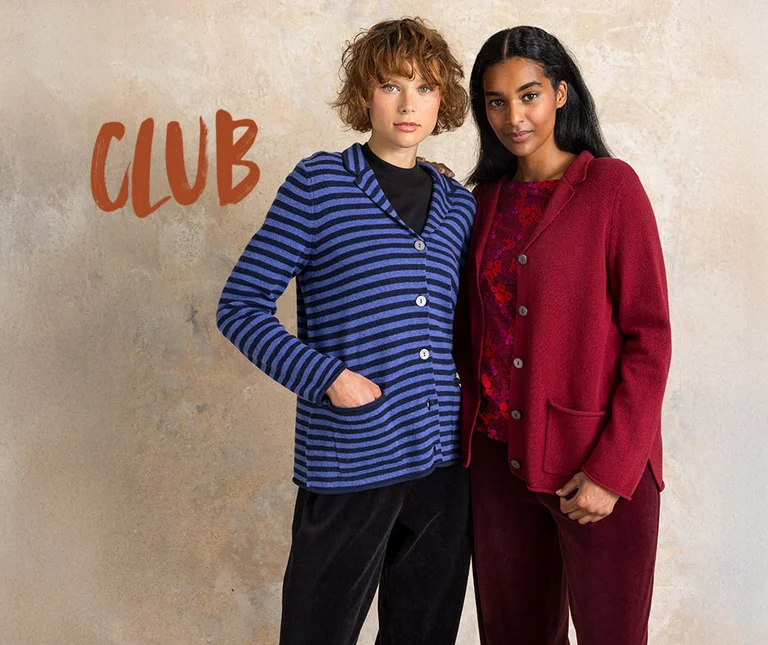 Two women wearing knit blazers from Gudrun Sjödén, one is blue striped, the other is red.