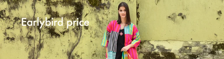 A woman wearing a colorful striped blouse from Gudrun Sjödén. She holds a matching shawl in her hand.