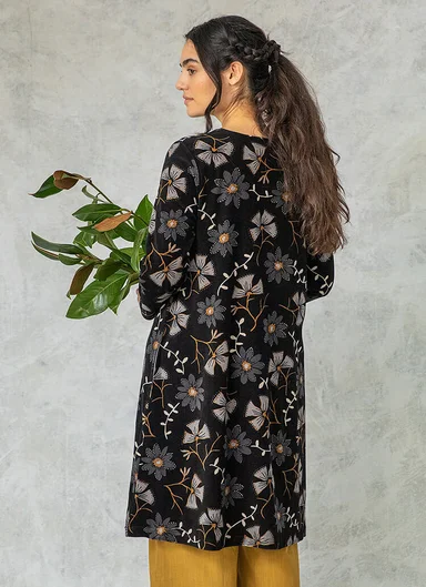 A woman wearing a patterned velour dress from Gudrun Sjödén. 