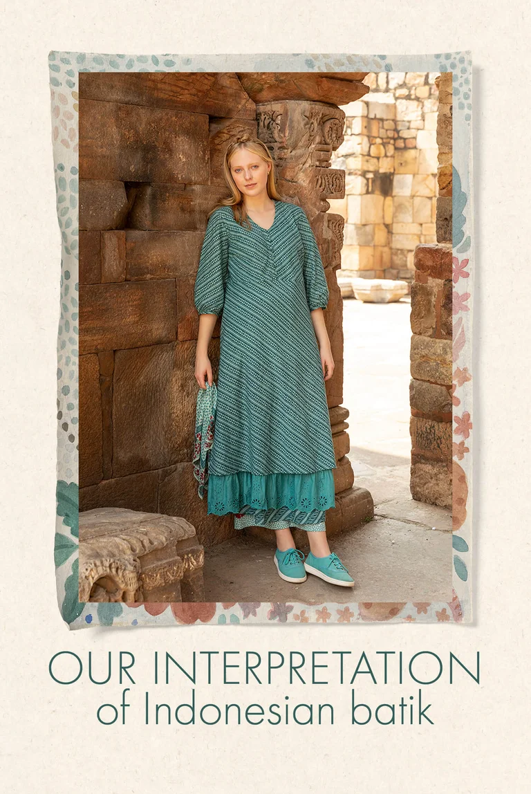 A woman wearing a striped green dress from Gudrun Sjödén.  