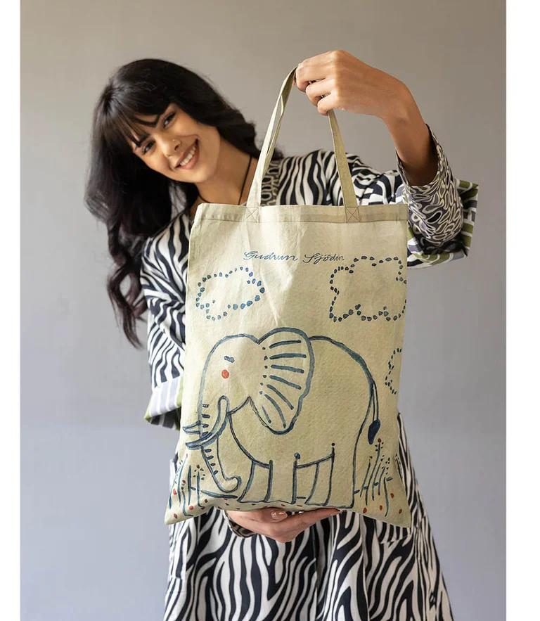 Eine Frau mit einer Elefanten-Stofftasche von Gudrun Sjödén.