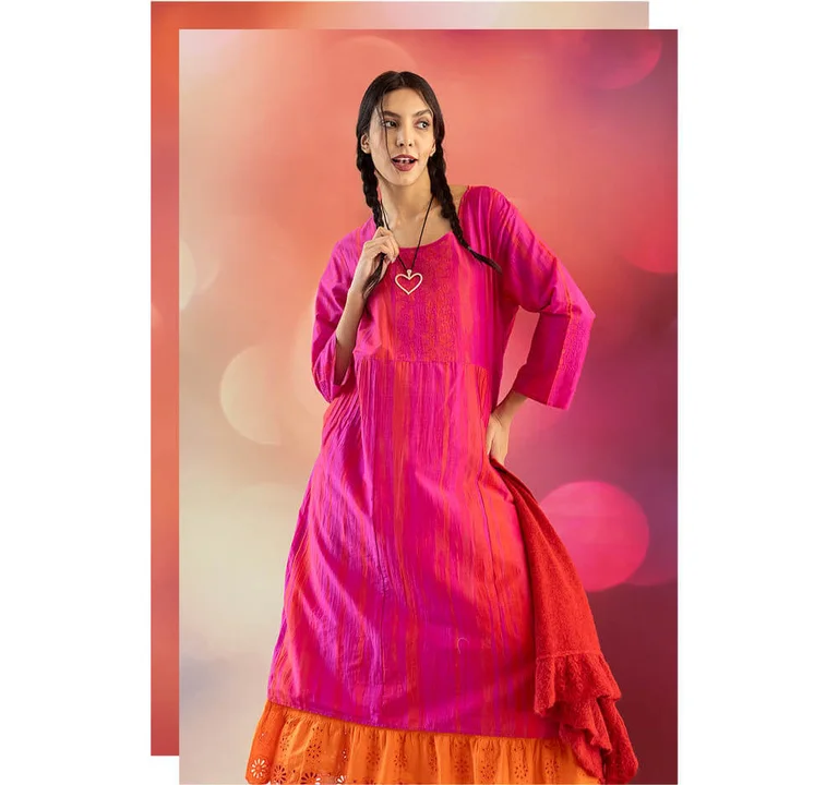 A woman wearing a pink, shimmering dress and a silver necklace from Gudrun Sjödén’s 2025 Christmas collection.