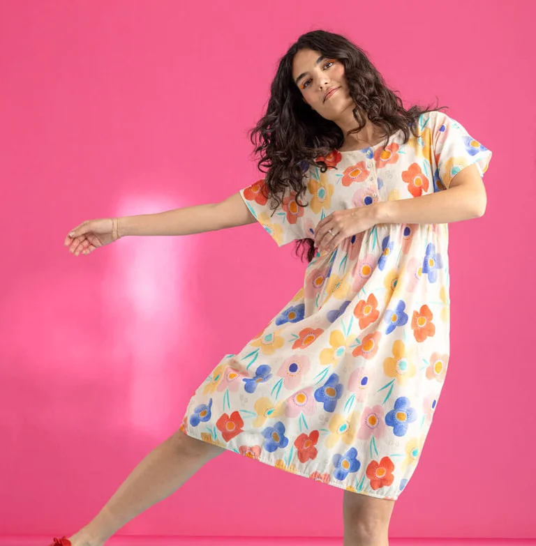 A woman wearing a floral dress from Gudrun Sjödén.  