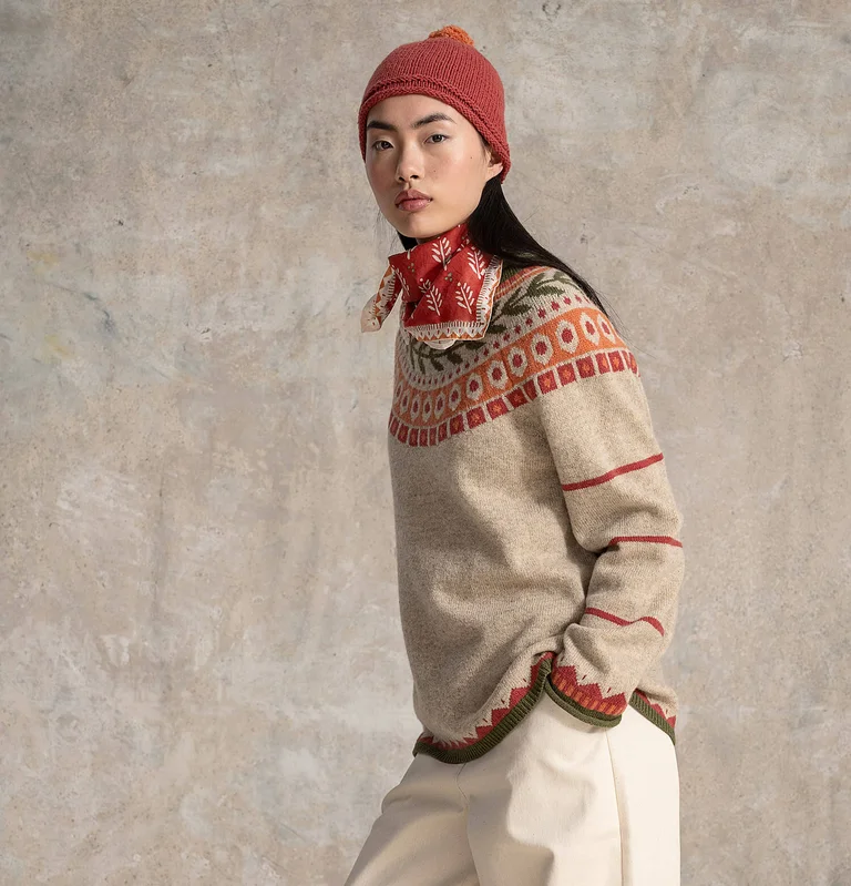 Eine Frau in einem gemusterten Strickpullover von Gudrun Sjödén.