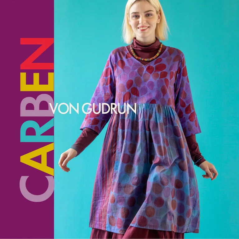 Eine Frau in einem lila gemusterten Kleid aus Gudrun Sjödéns Paris-Kollektion.  