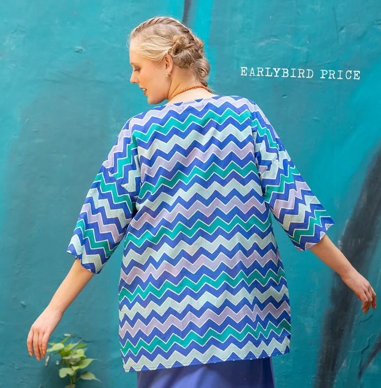 A woman wearing a patterned blouse from Gudrun Sjödén. 