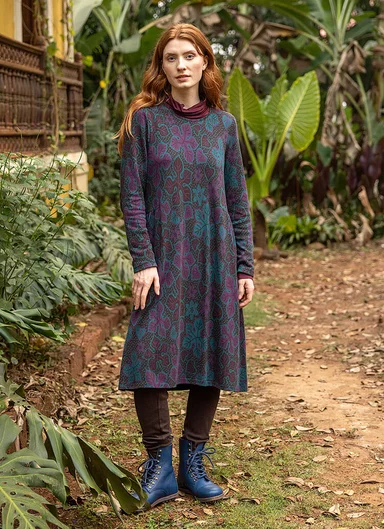 A woman wearing a patterned jersey dress from Gudrun Sjödén.