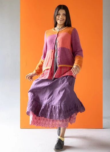 A woman wearing layers of colourful clothes from Gudrun Sjödén.