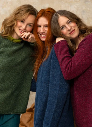 Three women close together wearing knitted essentials from Gudrun Sjödén.