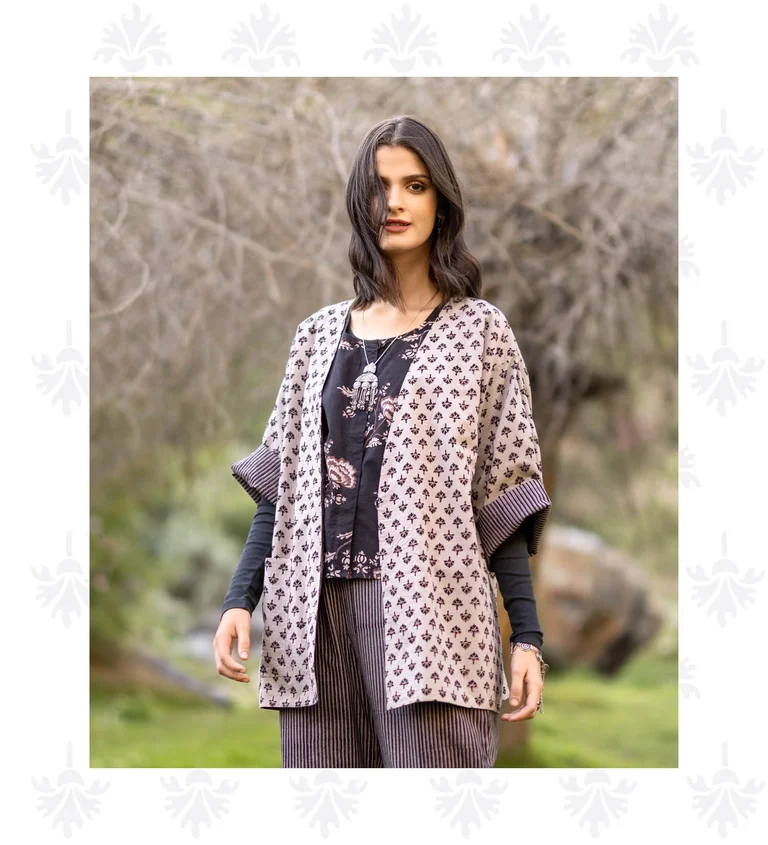 A woman wearing a floral blouse and patterned kimono from Gudrun Sjödén. 