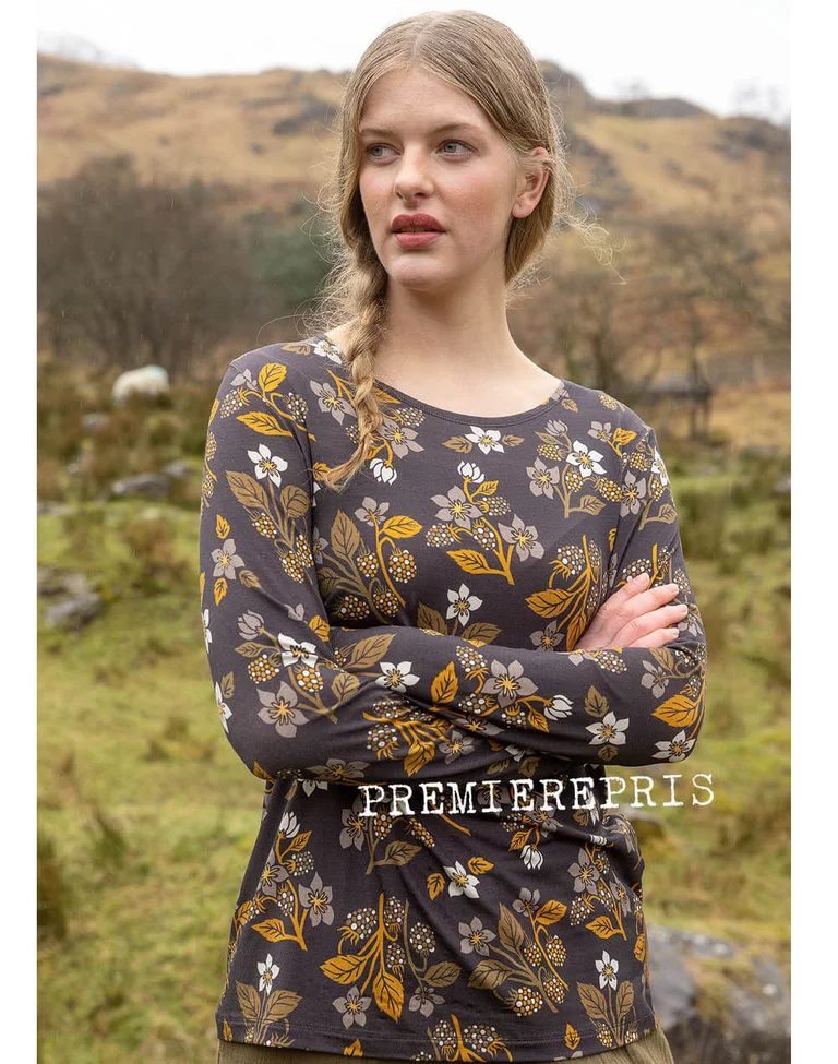 A woman wearing a patterned top from Gudrun Sjödén.