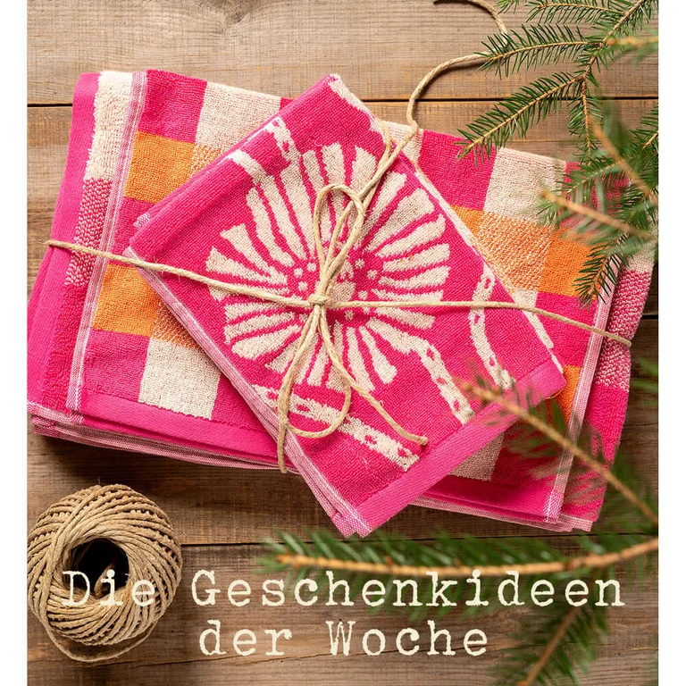 Frotteehandtücher in verschiedenen Größen von Gudrun Sjödén, gestapelt und mit Geschenkband verschnürt.