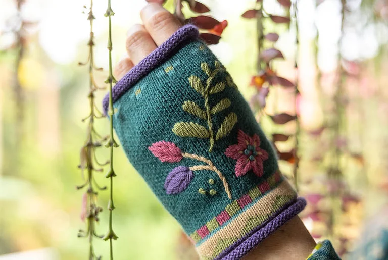 A woman wearing an embroidered cardigan from Gudrun Sjödén.  