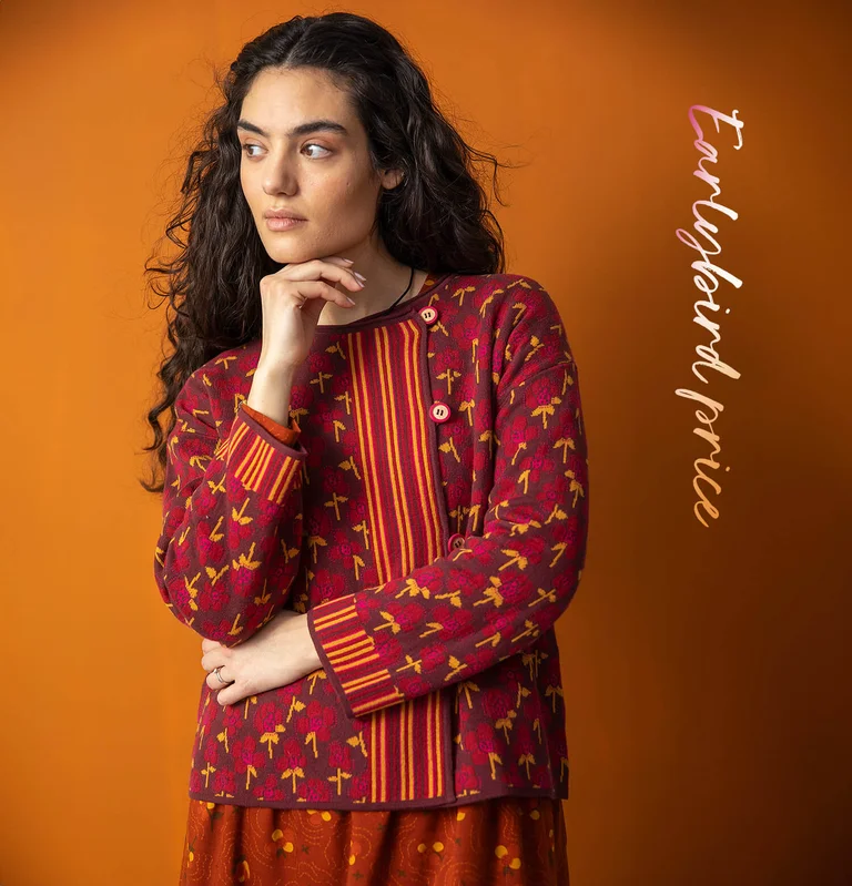 A woman wearing a floral red cardigan from Gudrun Sjödén. 