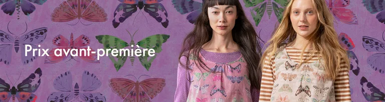 Deux femmes portant des vêtements à motifs de papillons se tiennent devant un fond violet assorti.