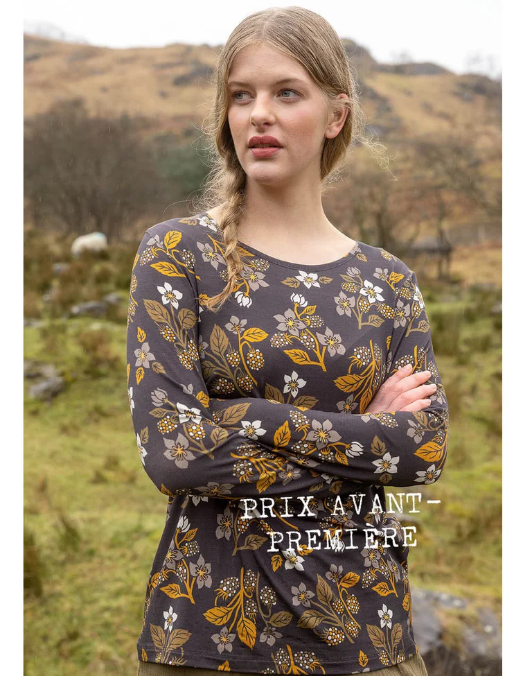 A woman wearing a patterned top from Gudrun Sjödén.