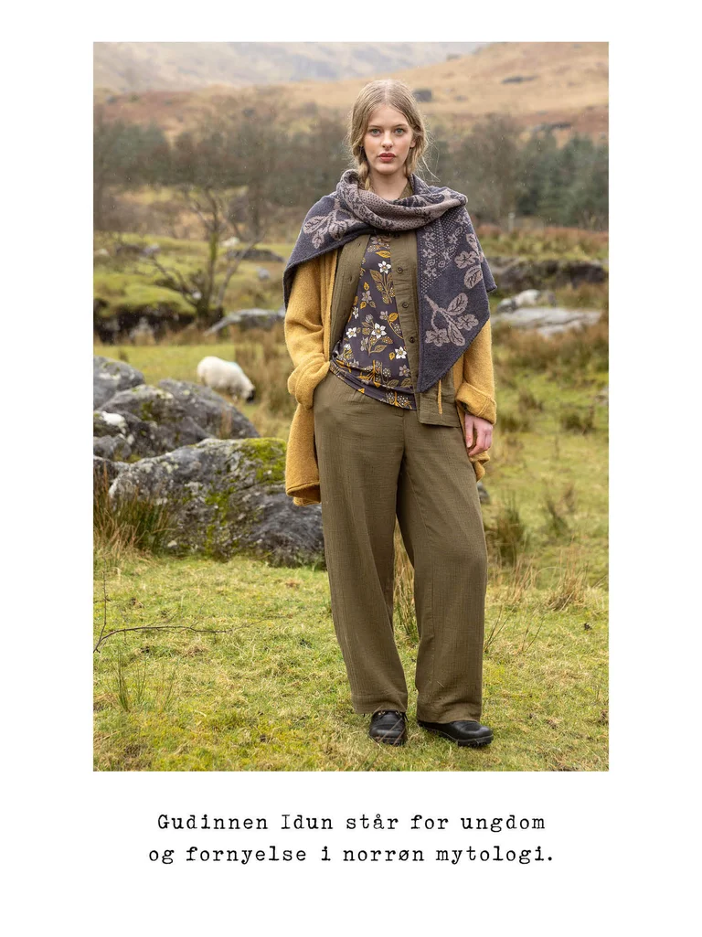 A woman posing outdoors wearing layers of clothing from Gudrun Sjödén.