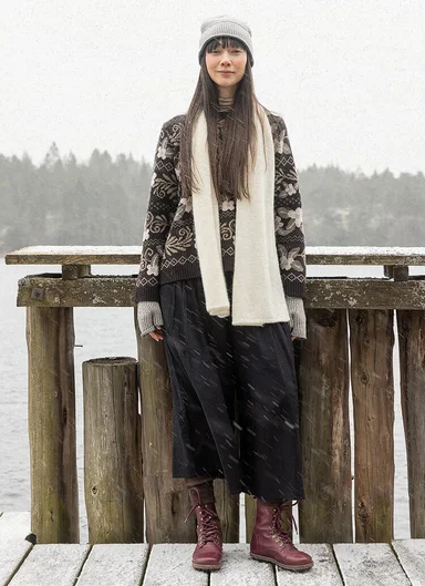 Eine Frau in einem geblümten Strickpullover von Gudrun Sjödén. 
