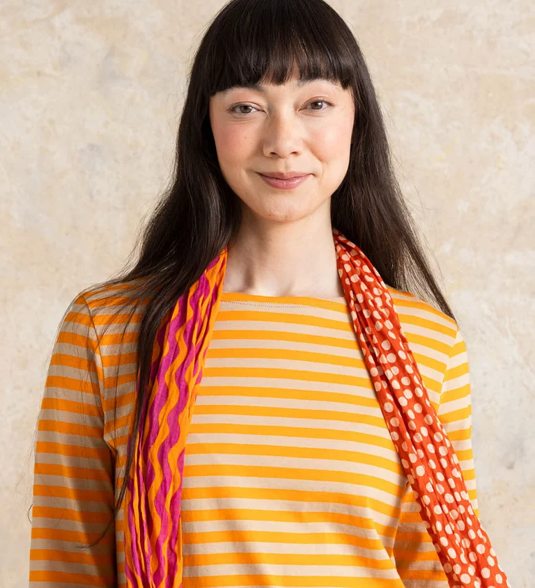 A woman wearing a striped long-sleeve sweater from Gudrun Sjödén.
