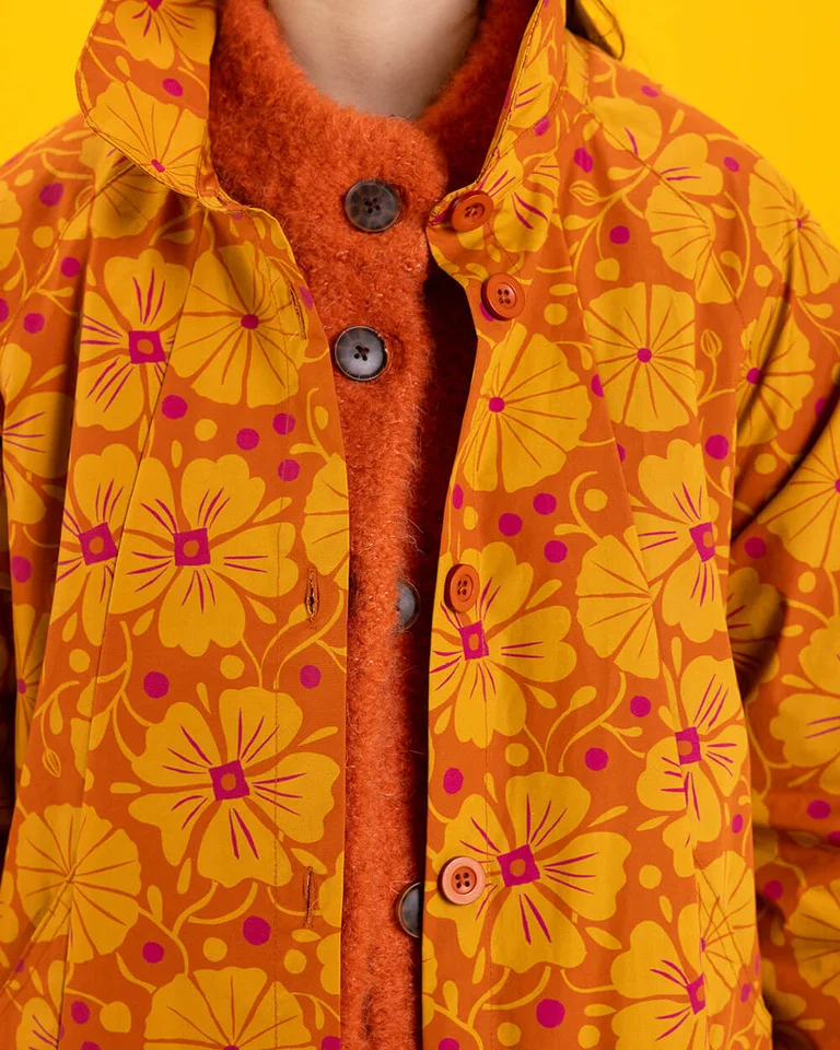 A closeup of a patterned orange coat from Gudrun Sjödén.