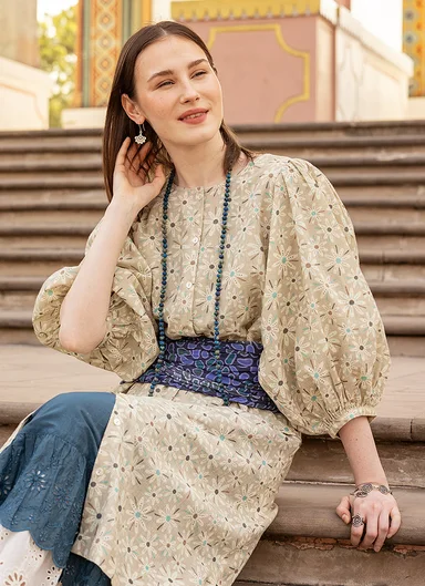 A woman wearing layers of woven patterned clothes in shades of blue from Gudrun Sjödén.