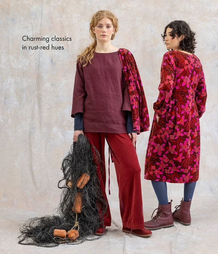 Two women wearing clothing in shades of red from Gudrun Sjödén. 