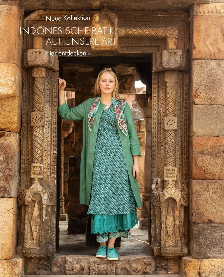 Eine Frau in einem gemusterten Kleid von Gudrun Sjödén. 