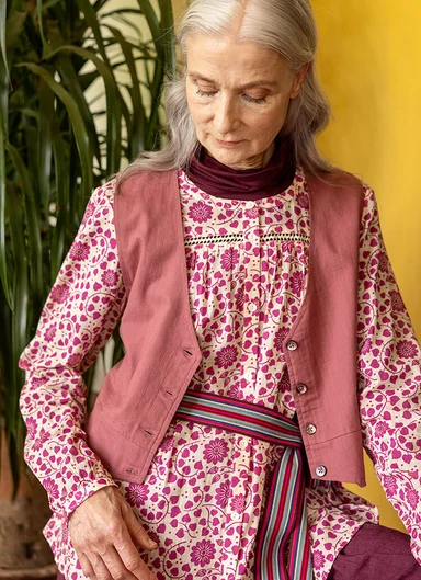 A woman wearing a floral blouse from Gudrun Sjödén. 