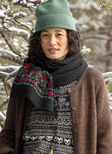 A woman standing in the forest wearing clothes from Gudrun Sjödén. 