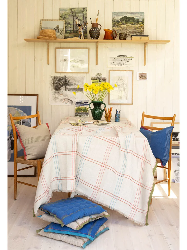 A table with a checked tablecloth and chairs with cushions in a linen blend from Gudrun Sjödén.