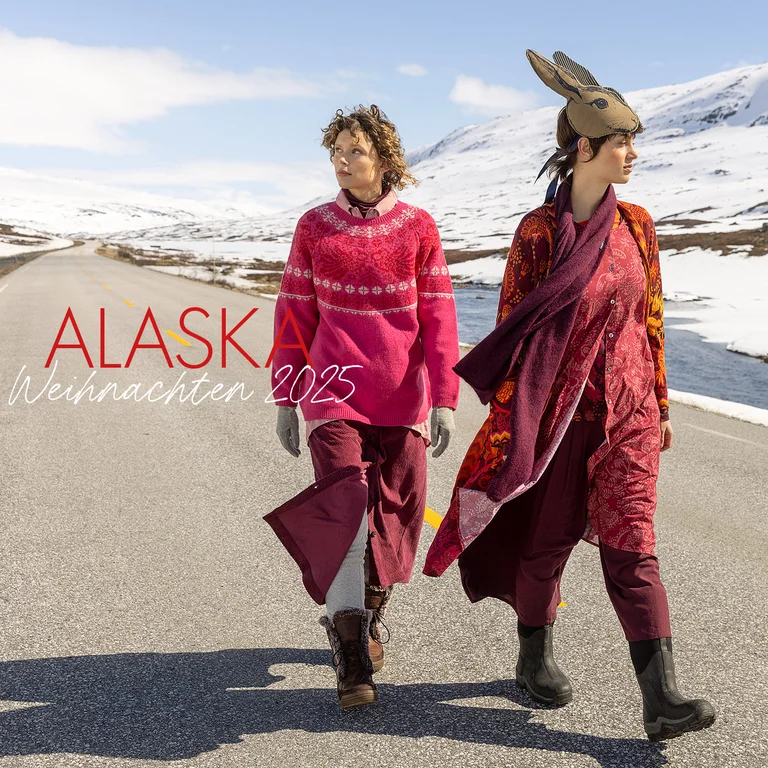Zwei Frauen auf einer Straße in verschneiter Landschaft, in Mode aus Gudrun Sjödéns Weihnachtskollektion 2025. 
