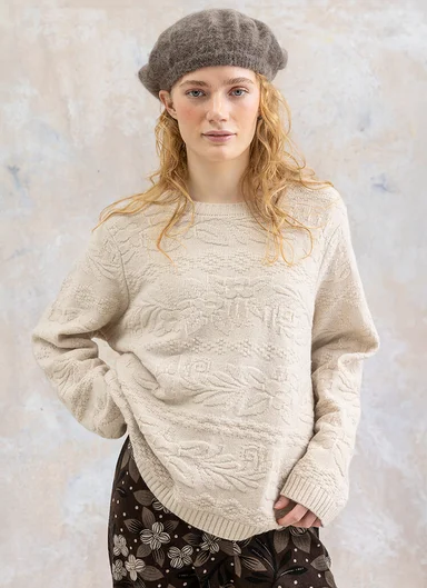 Eine Frau in einem Strickpullover von Gudrun Sjödén. 