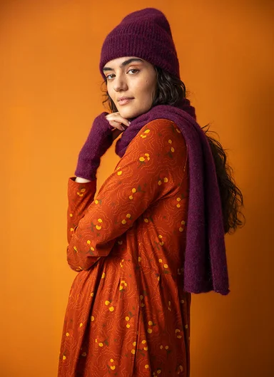 A woman wearing a knitted beanie and scarf from Gudrun Sjödén. 