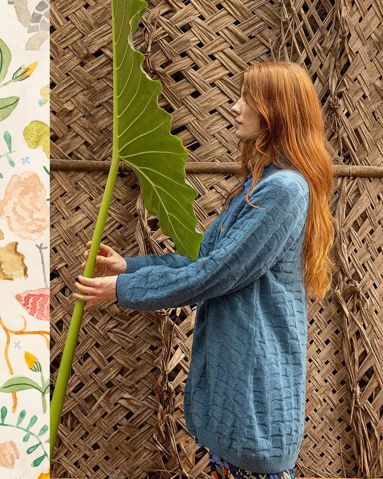 A woman wearing a blue cardigan from Gudrun Sjödén.