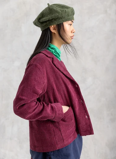 Eine Frau in einer Cordjacke von Gudrun Sjödén.