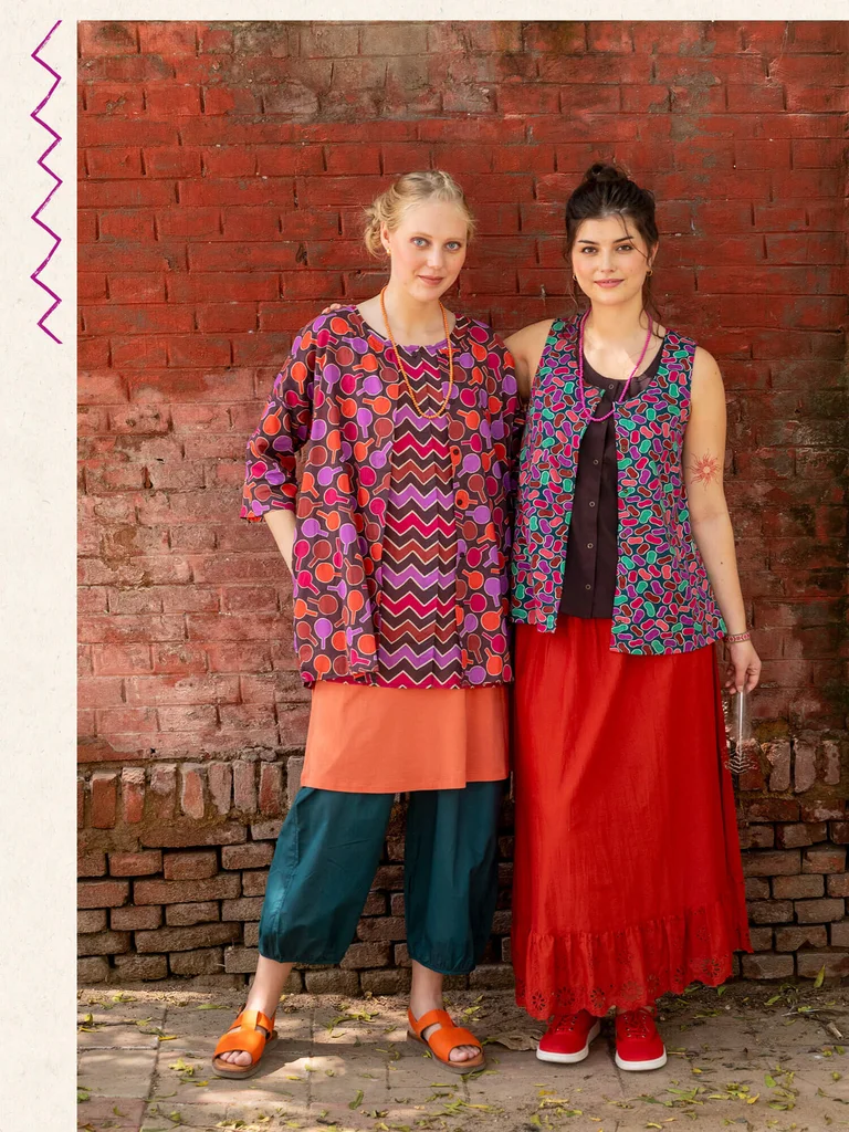 Two women wearing colorful and patterned clothing from Gudrun Sjödén.