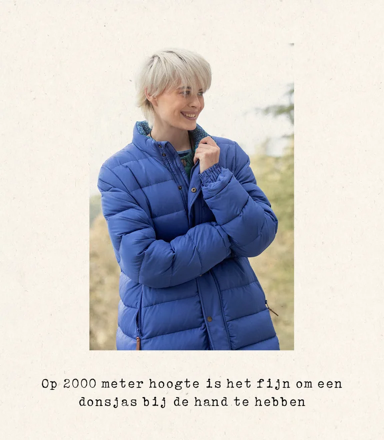 A woman wearing a blue down coat from Gudrun Sjödén.