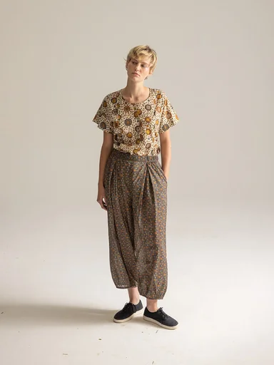 A woman wearing a patterned tunic and trousers from Gudrun Sjödén.