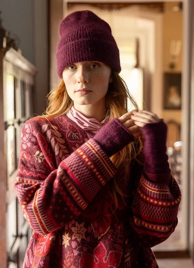 A woman wearing a knitted beanie and scarf from Gudrun Sjödén. 